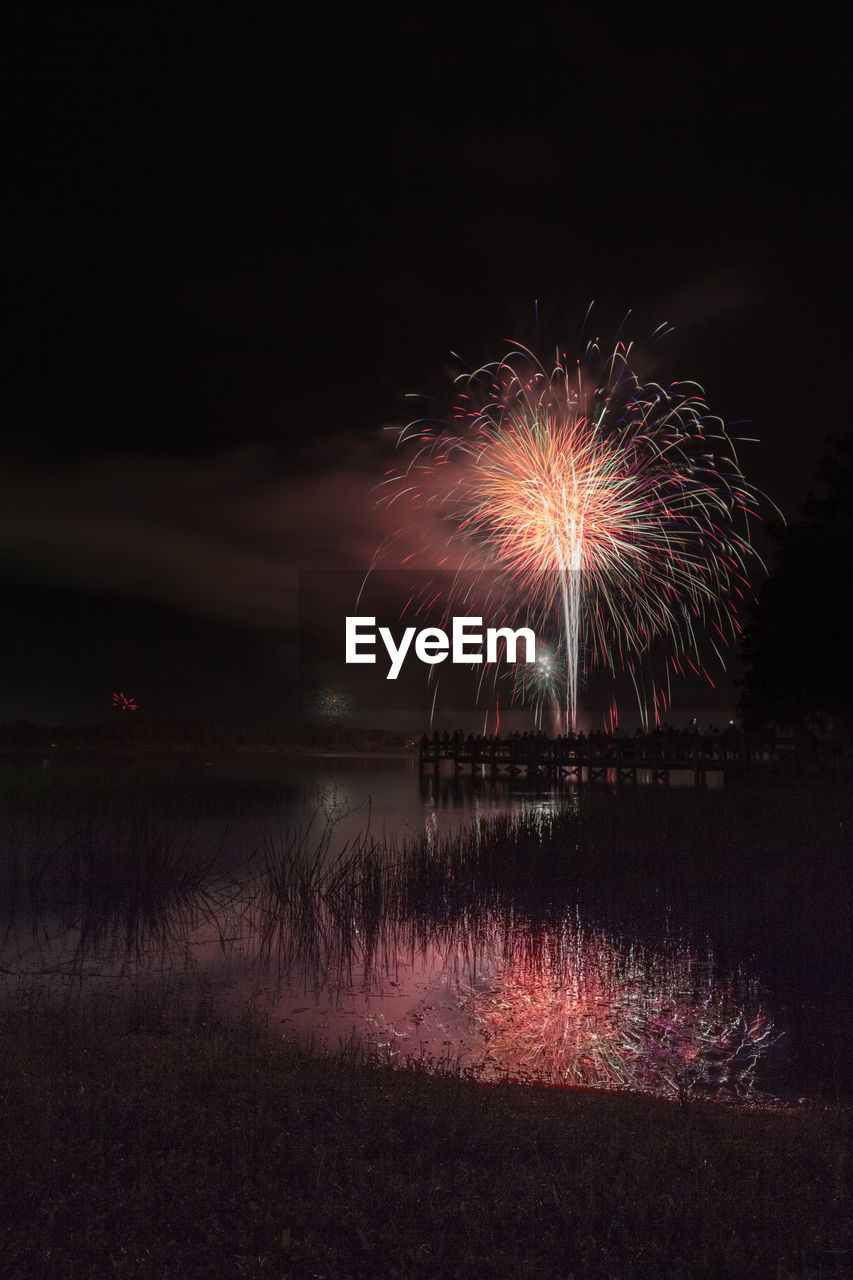 FIREWORK DISPLAY OVER LAKE AGAINST SKY