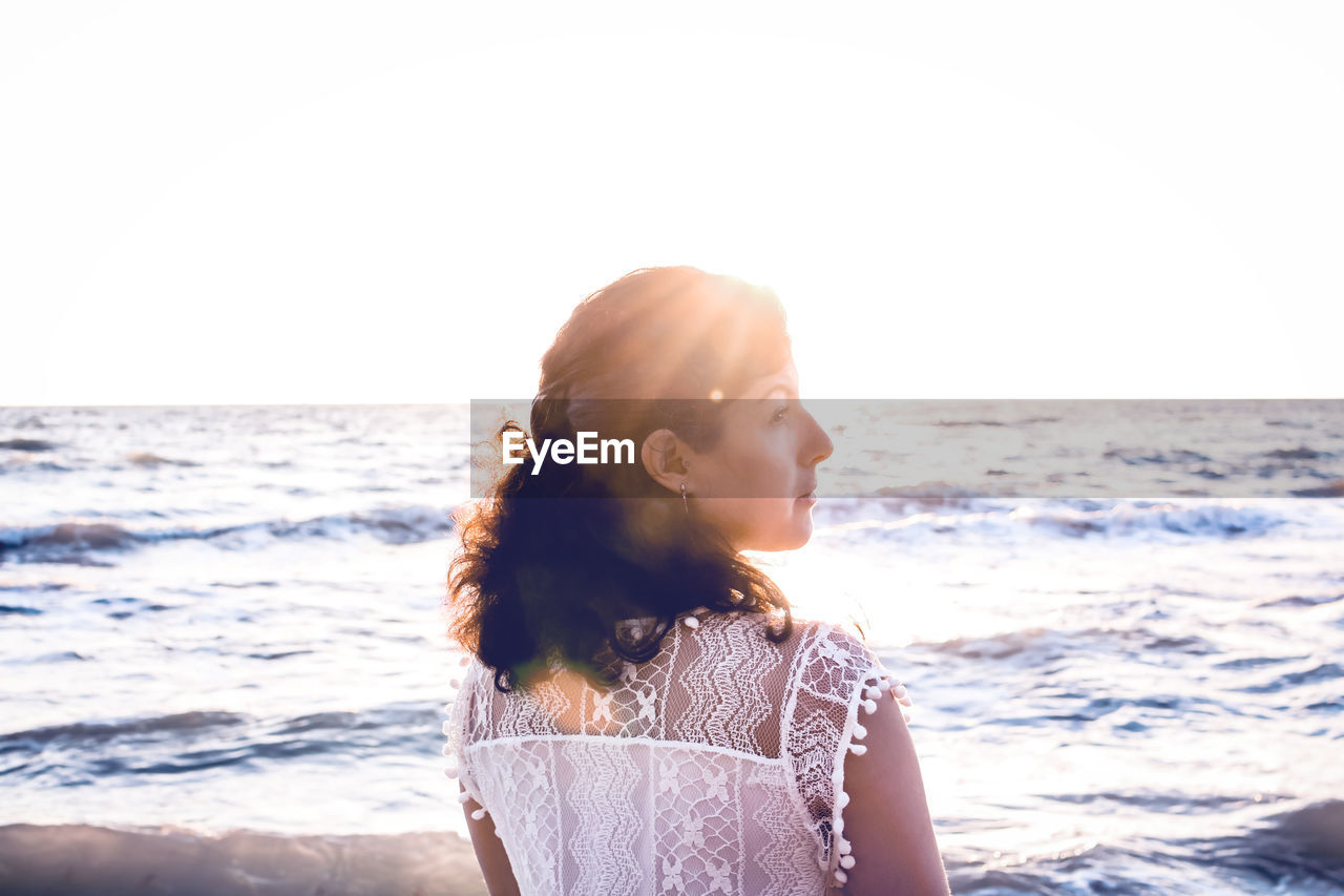 Woman at beach against clear sky