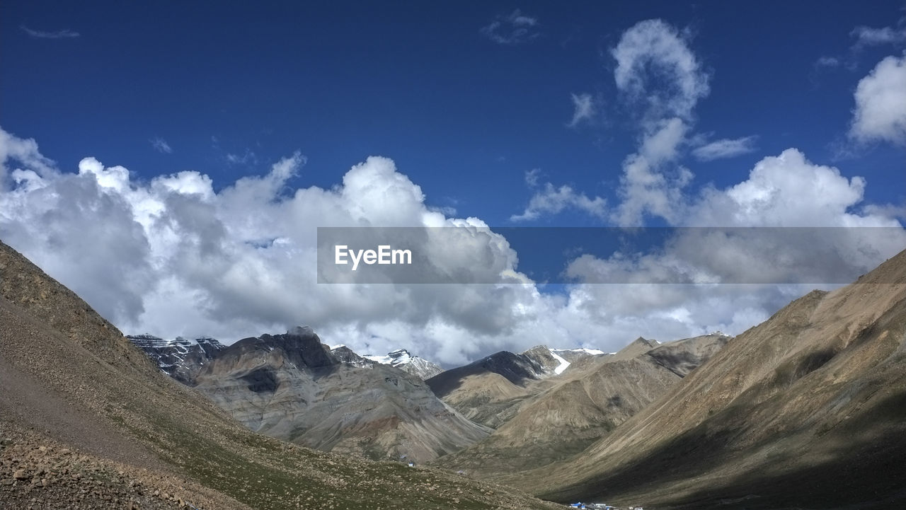 mountain, cloud, sky, environment, landscape, scenics - nature, mountain range, beauty in nature, nature, mountain pass, travel, land, travel destinations, non-urban scene, panoramic, blue, valley, no people, tranquility, ridge, outdoors, plateau, tranquil scene, day, tourism, activity, road, leisure activity, wilderness, cloudscape, transportation, idyllic, holiday, rock, geology