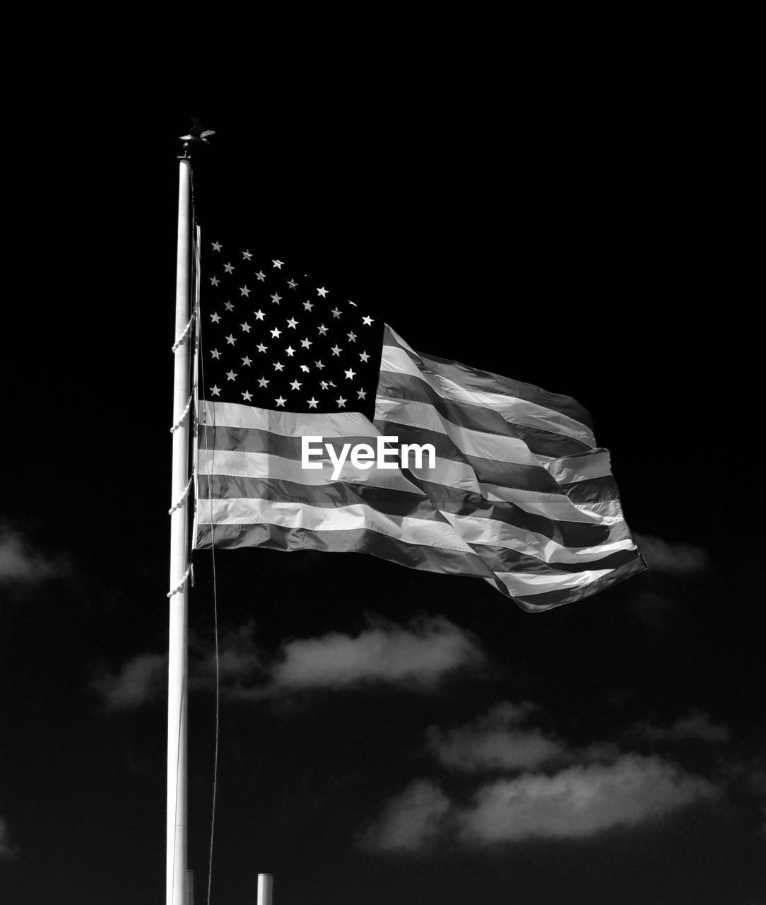 Low angle view of american flag fluttering against sky