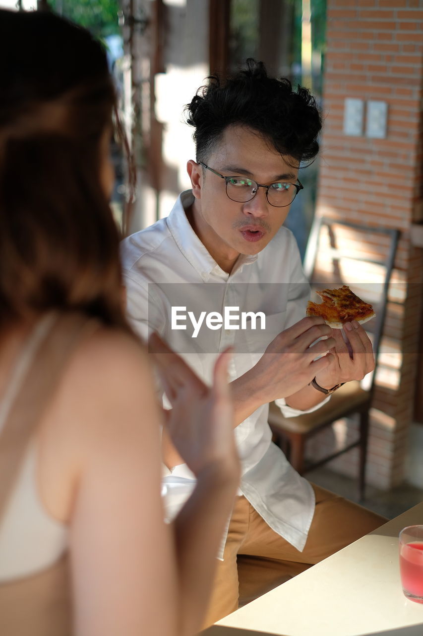 WOMAN LOOKING AWAY WHILE SITTING AT TABLE