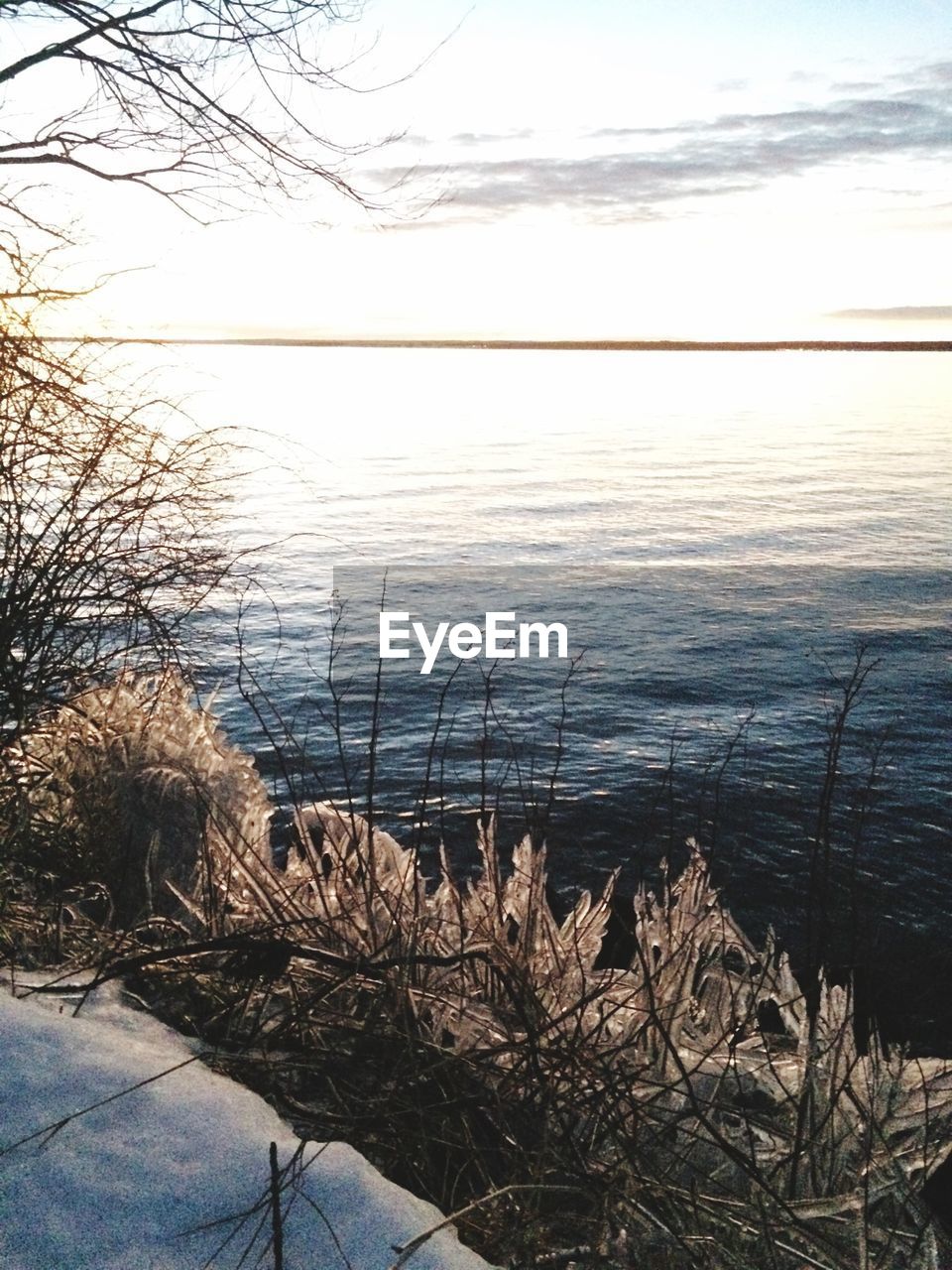 View of lake from shore in winter