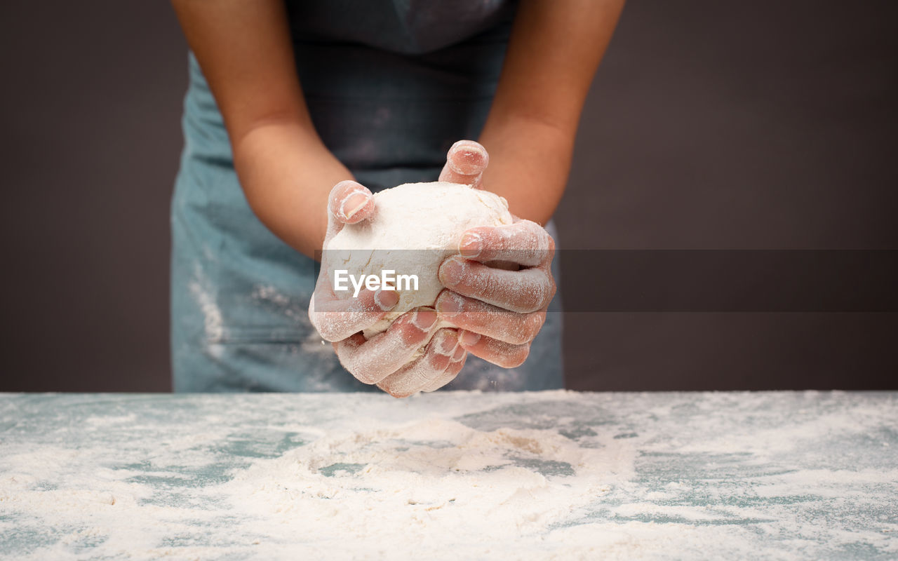 Baker kneading dough for pizza or artisan bread, prepare ingredients for food, baking pastry
