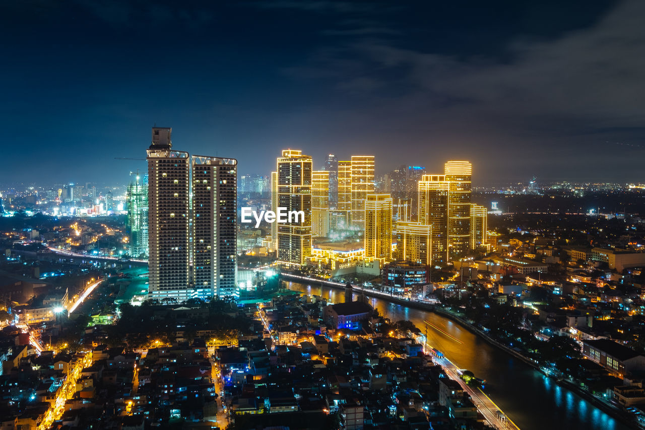 Illuminated cityscape against sky at night