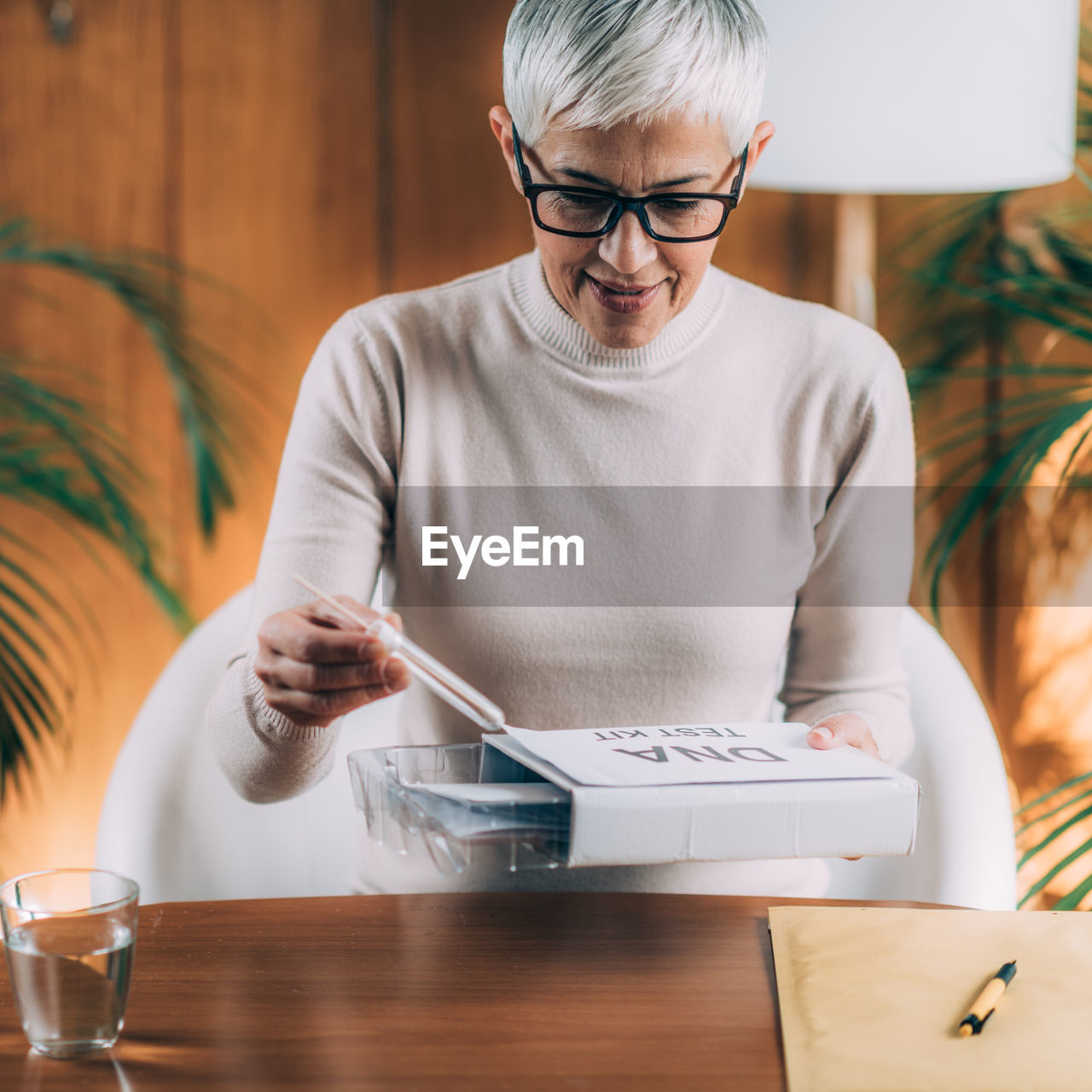 Midsection of man holding paper while sitting on table at home