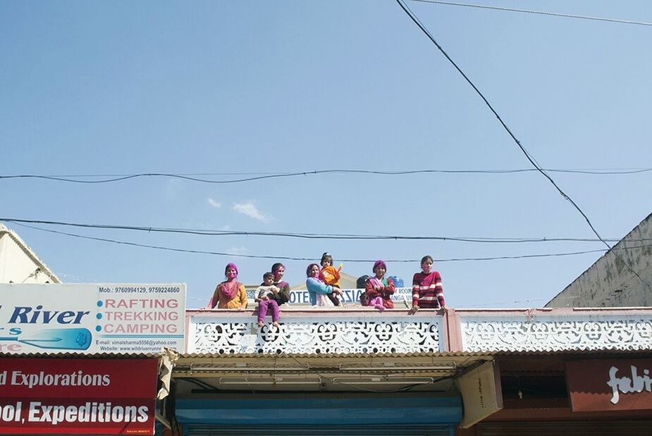 LOW ANGLE VIEW OF WOMAN STANDING AGAINST SKY