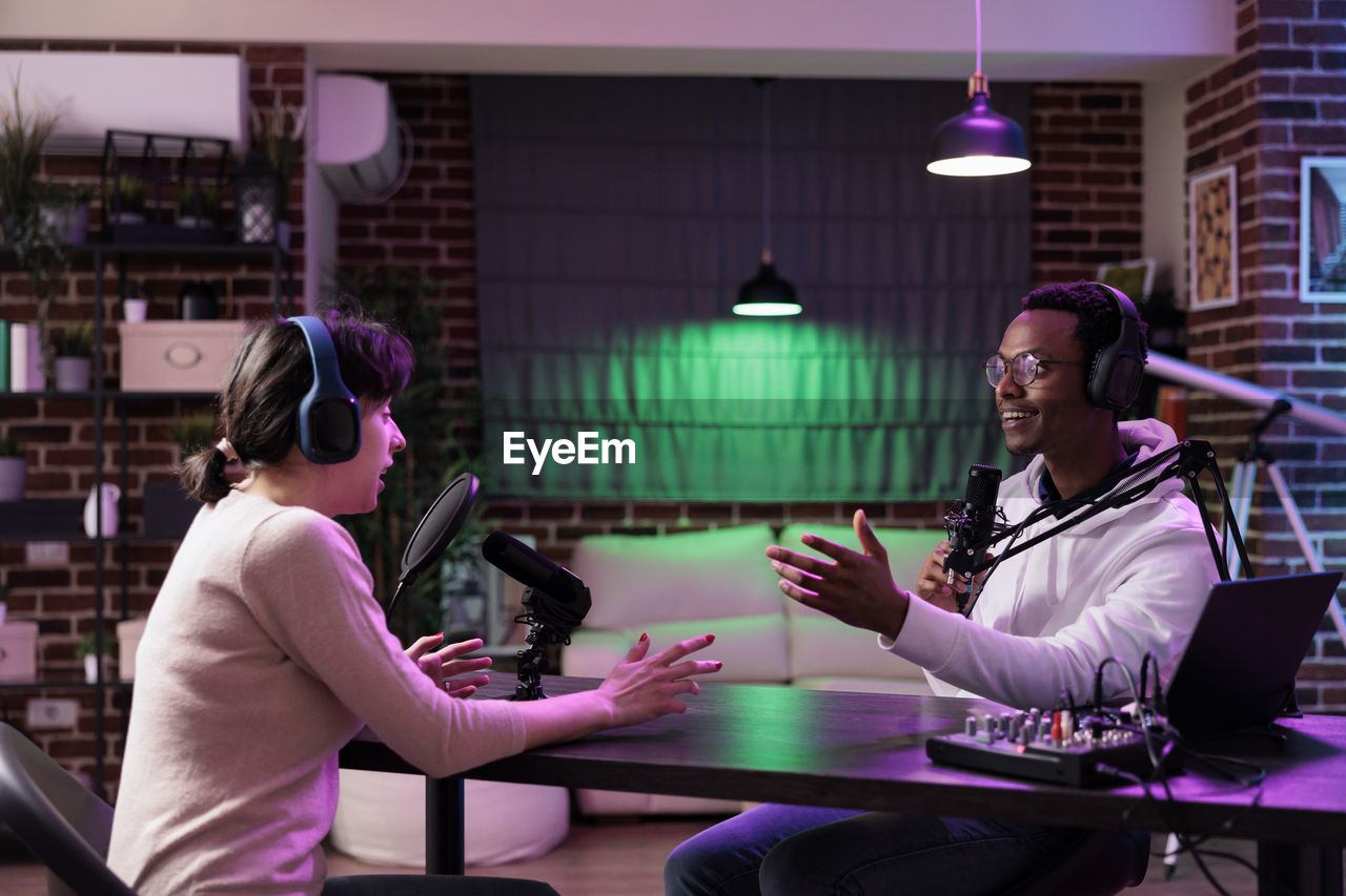 Man and woman podcasting at studio