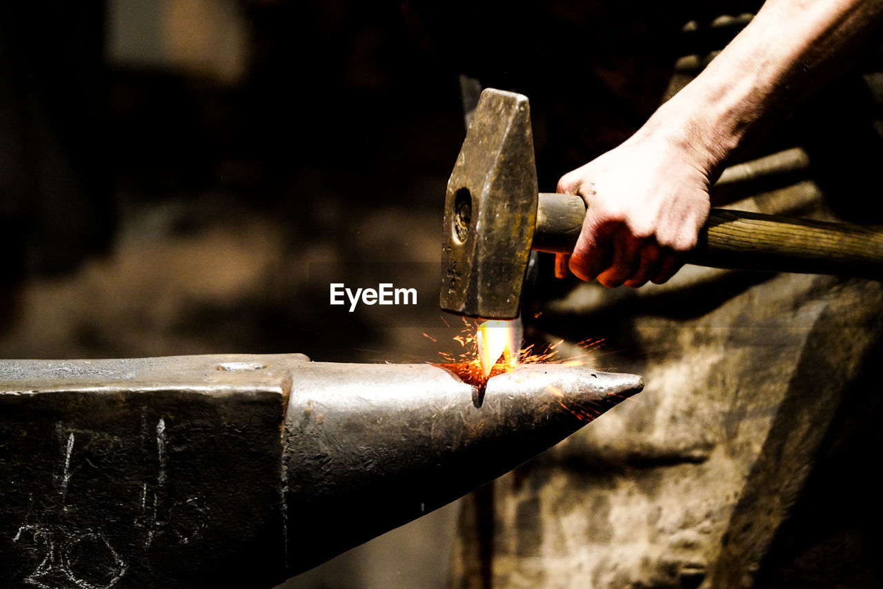 Cropped hand of man working in workshop - blacksmith  