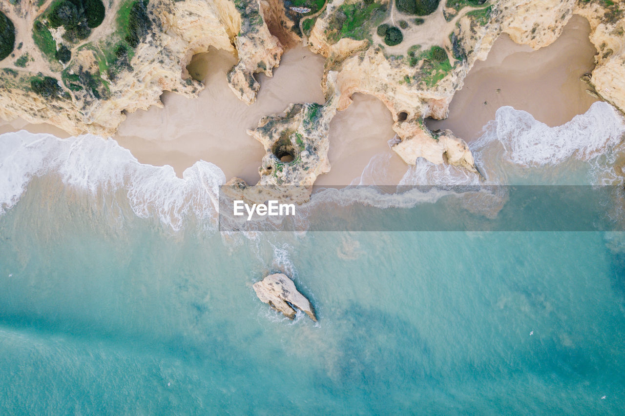 HIGH ANGLE VIEW OF ROCKS IN WATER