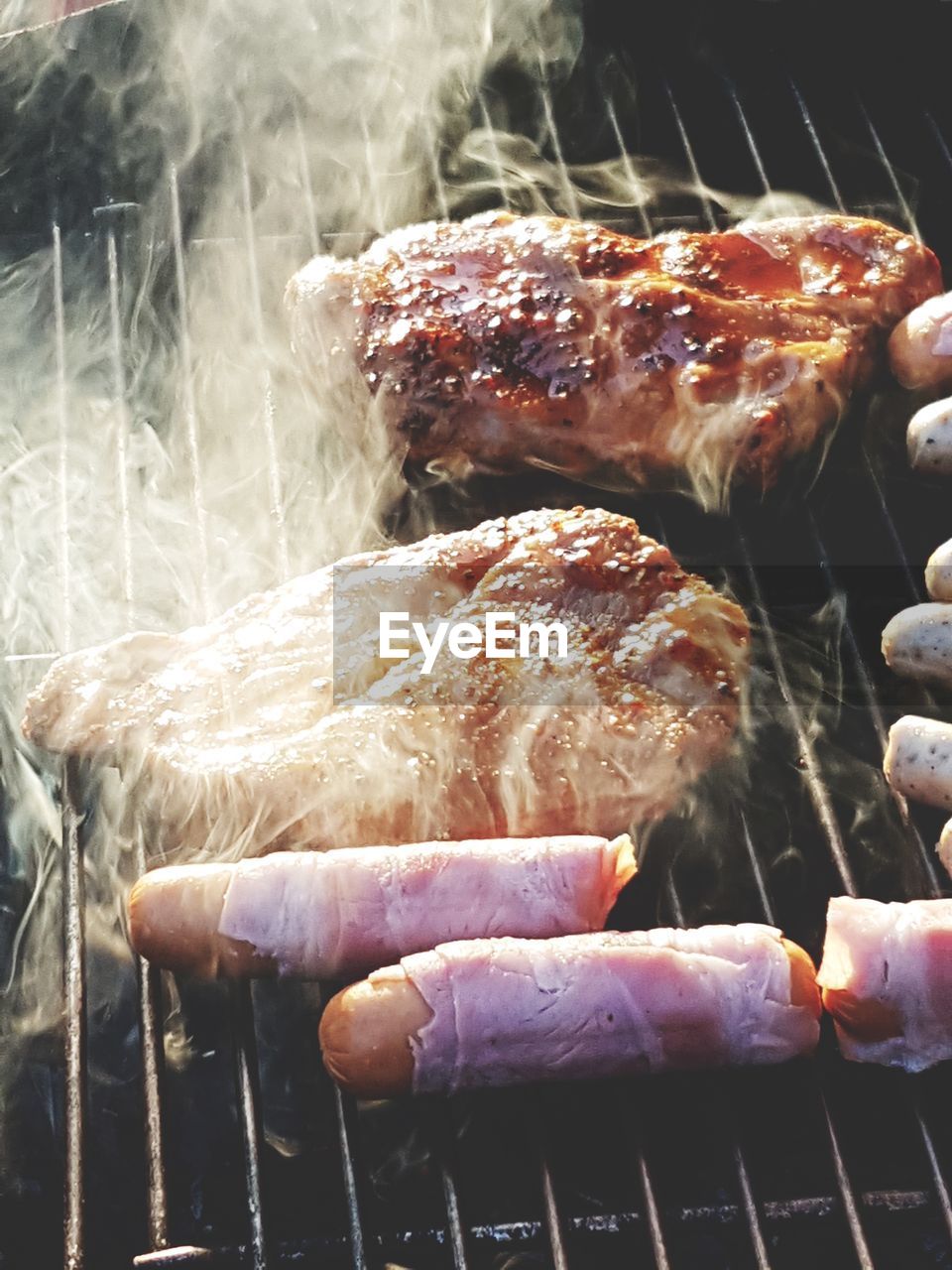 CLOSE-UP OF MEAT COOKING ON BARBECUE