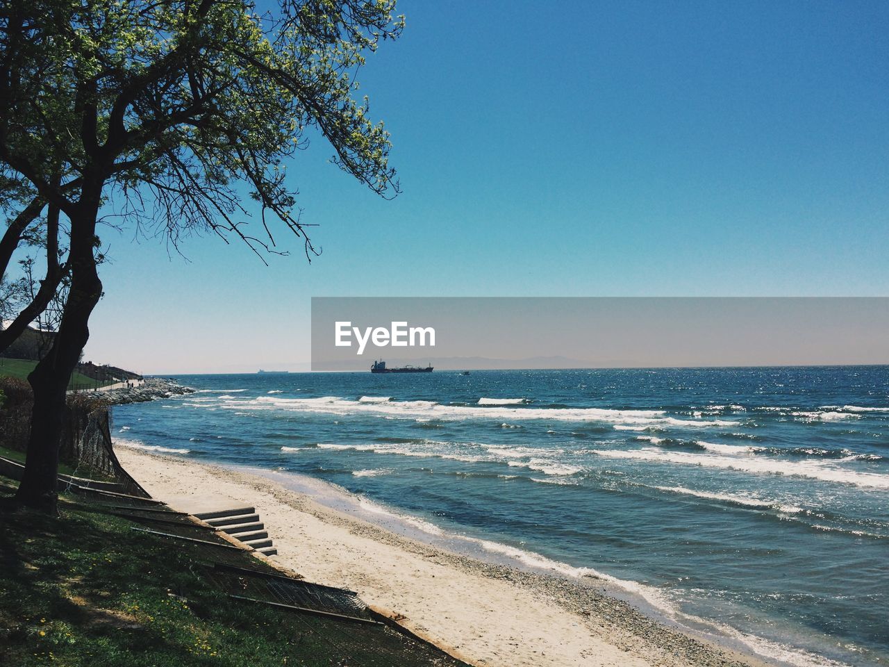 Scenic view of beach against clear blue sky