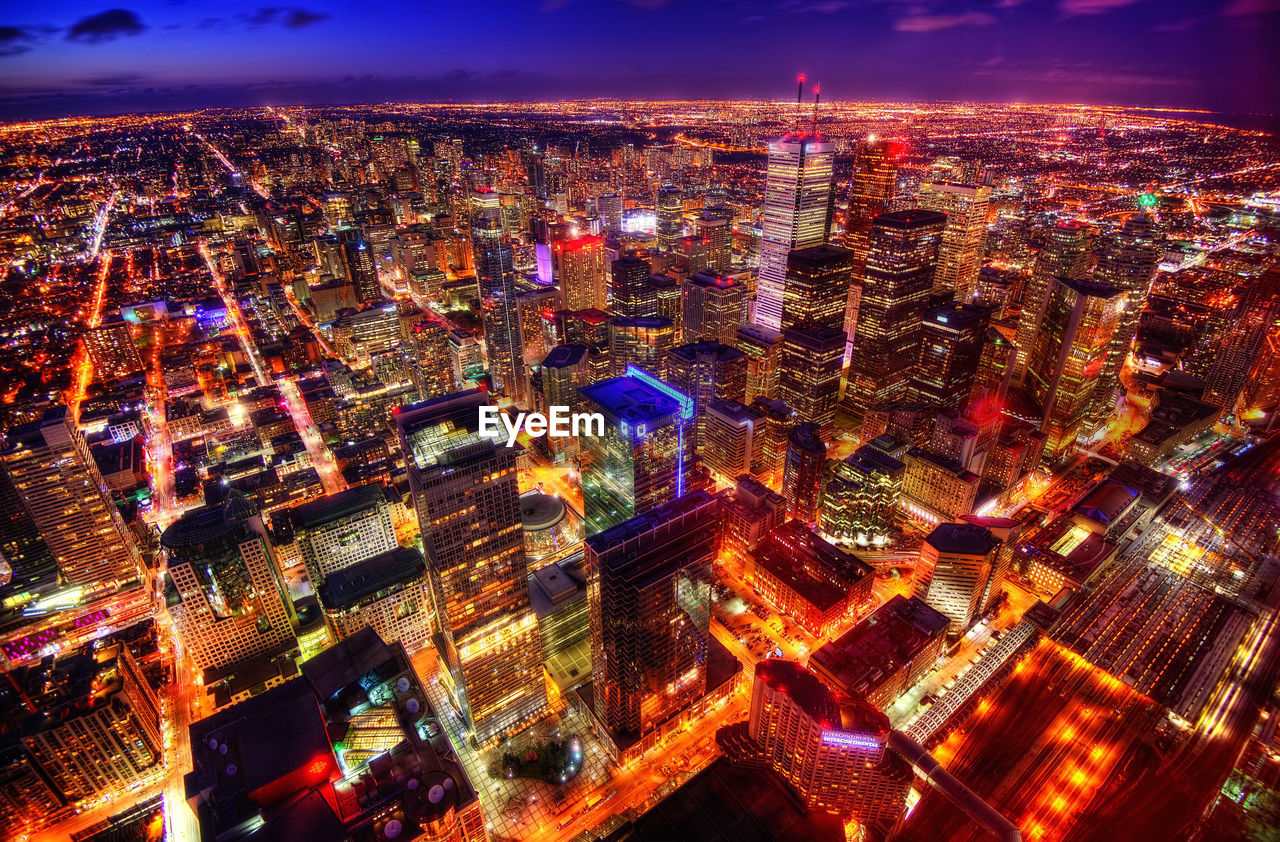 Aerial view of illuminated cityscape against sky at night