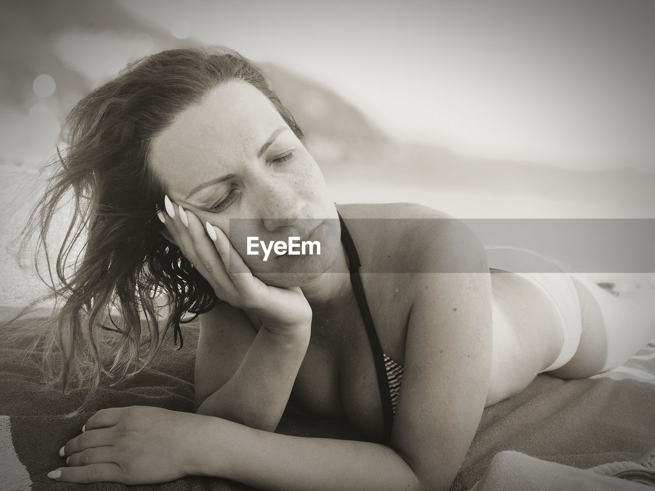 Close-up of young woman lying on beach