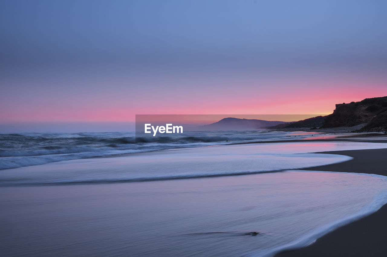 Scenic view of beach against sky during sunset