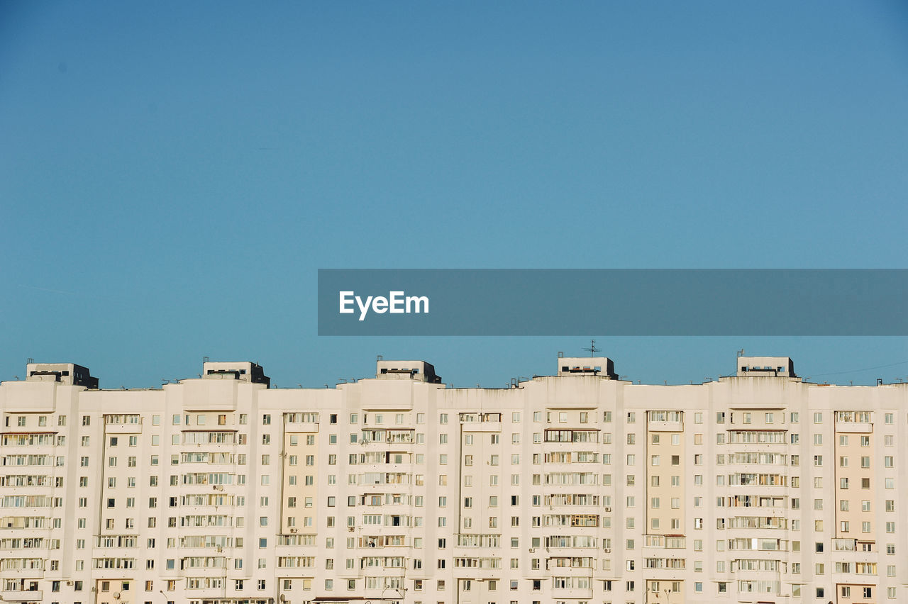 Low angle view of buildings against clear blue sky