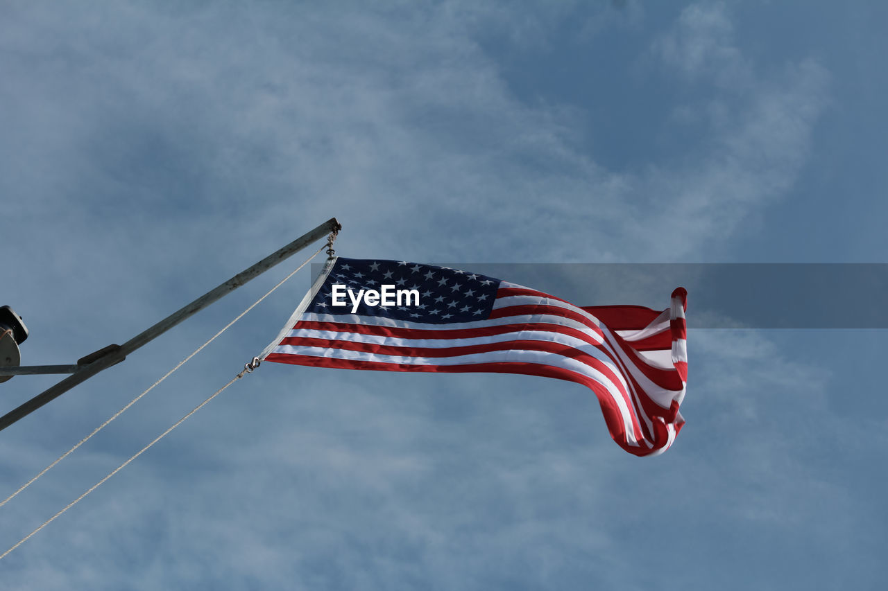 Low angle view of american flag against sky