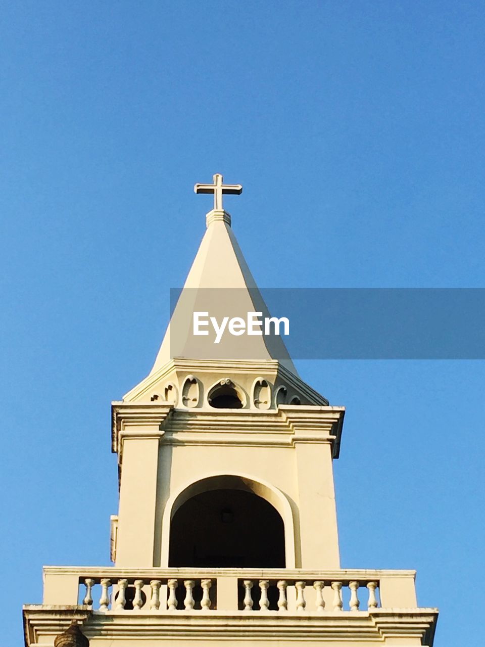 Low angle view of bell tower against blue sky