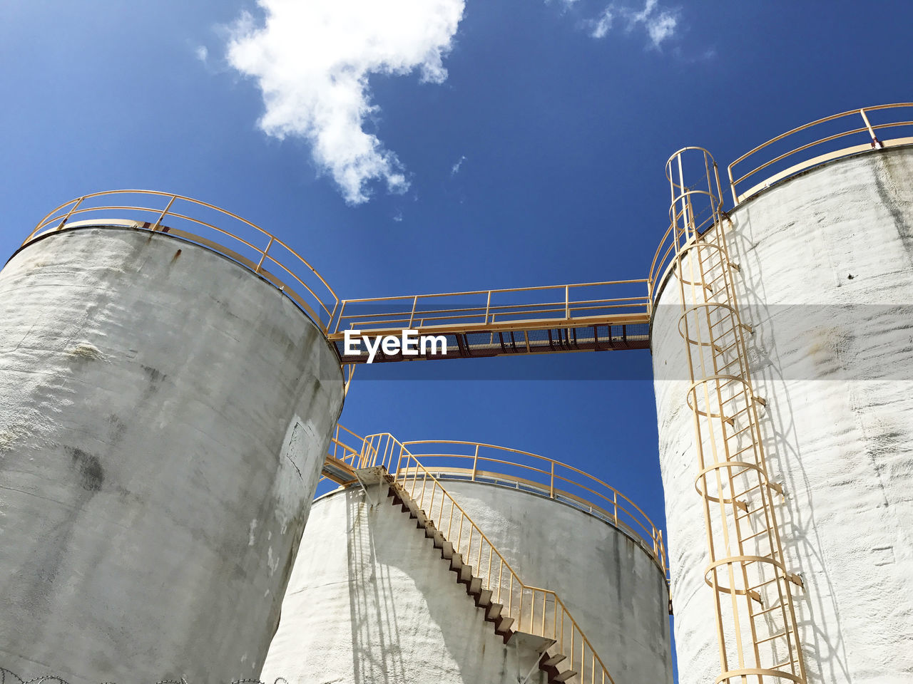 Low angle view of storage tanks against sky