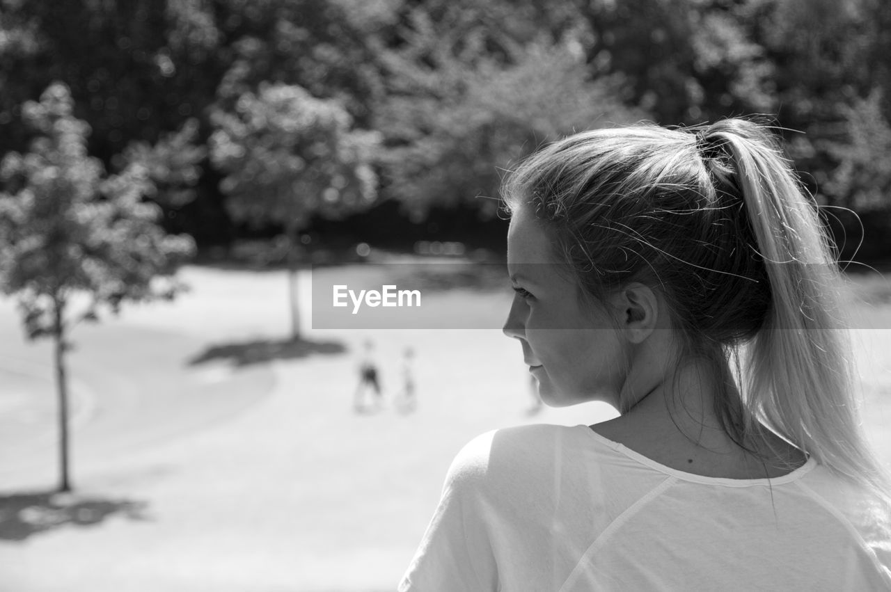 Close-up of young woman against trees