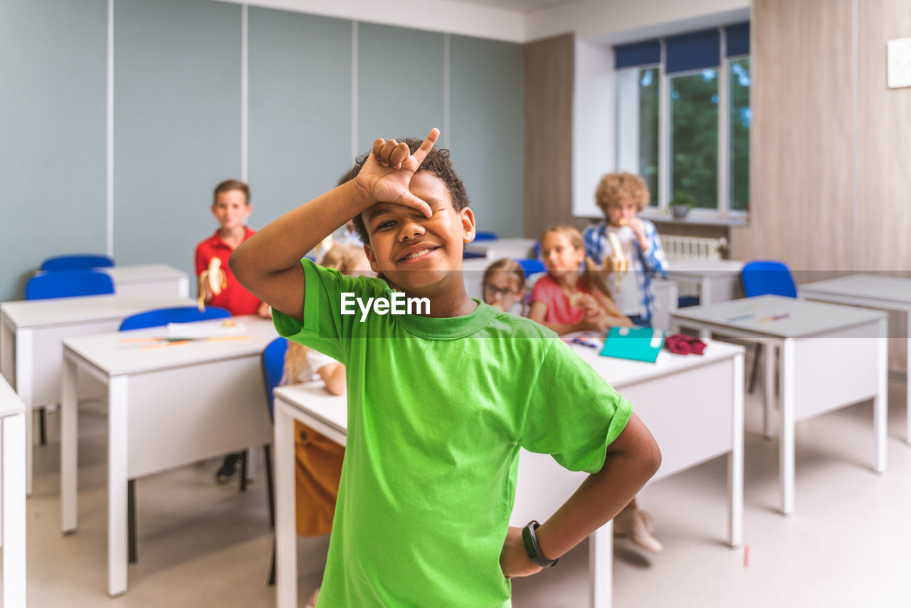 Portrait of cute girl gesturing at classroom