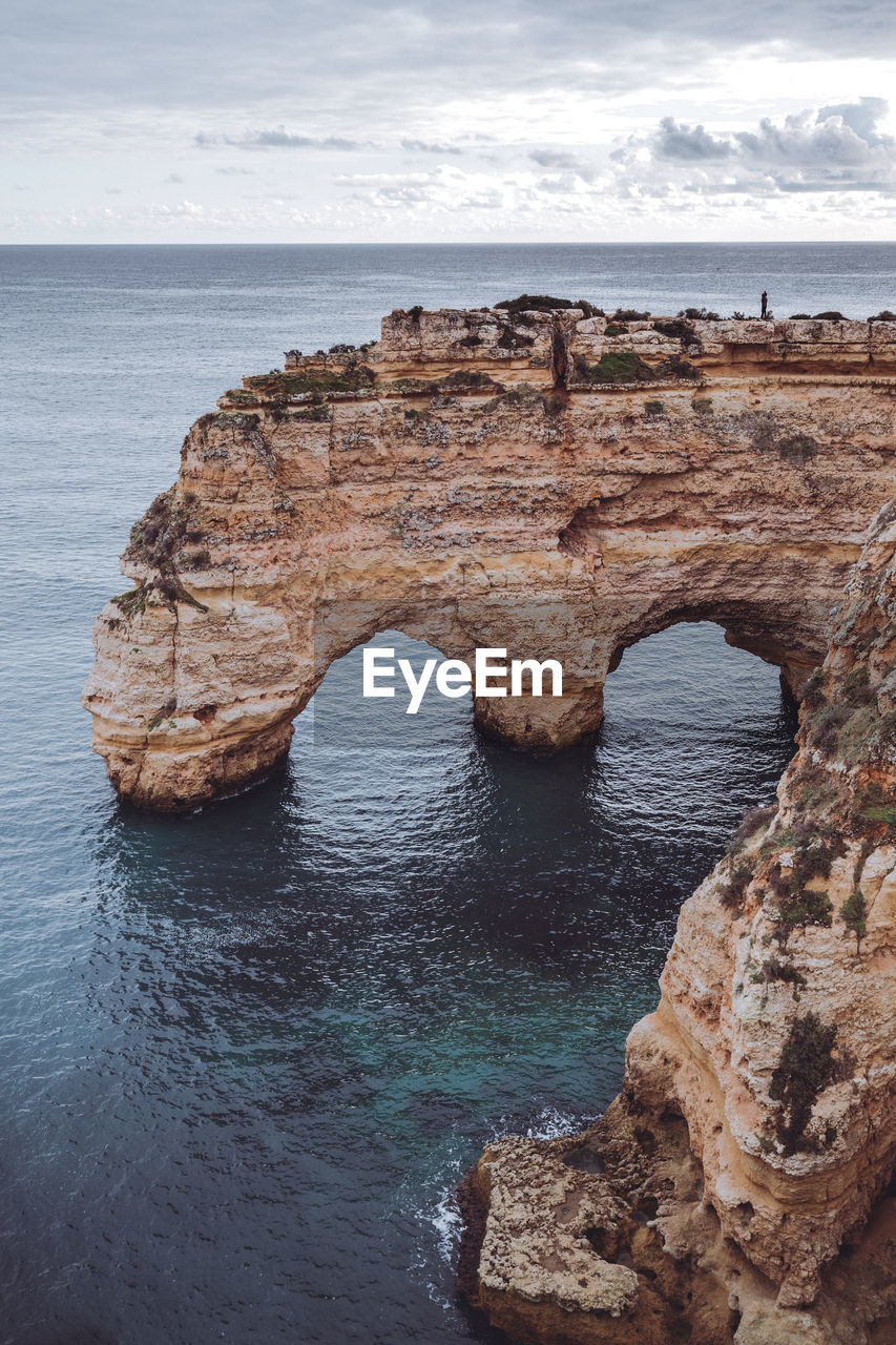 Rock formation in sea against sky