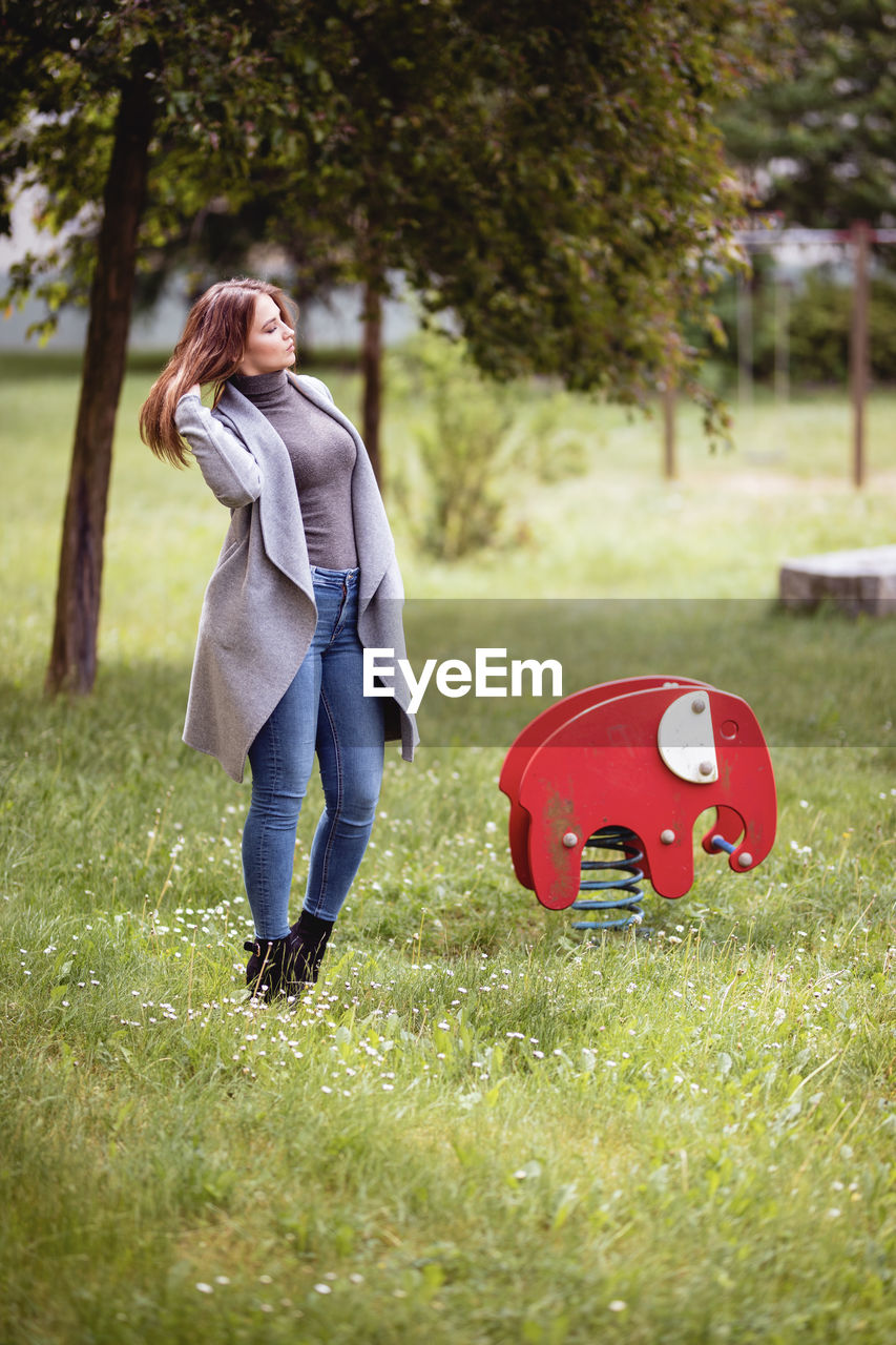 WOMAN WITH RED WALKING ON FIELD