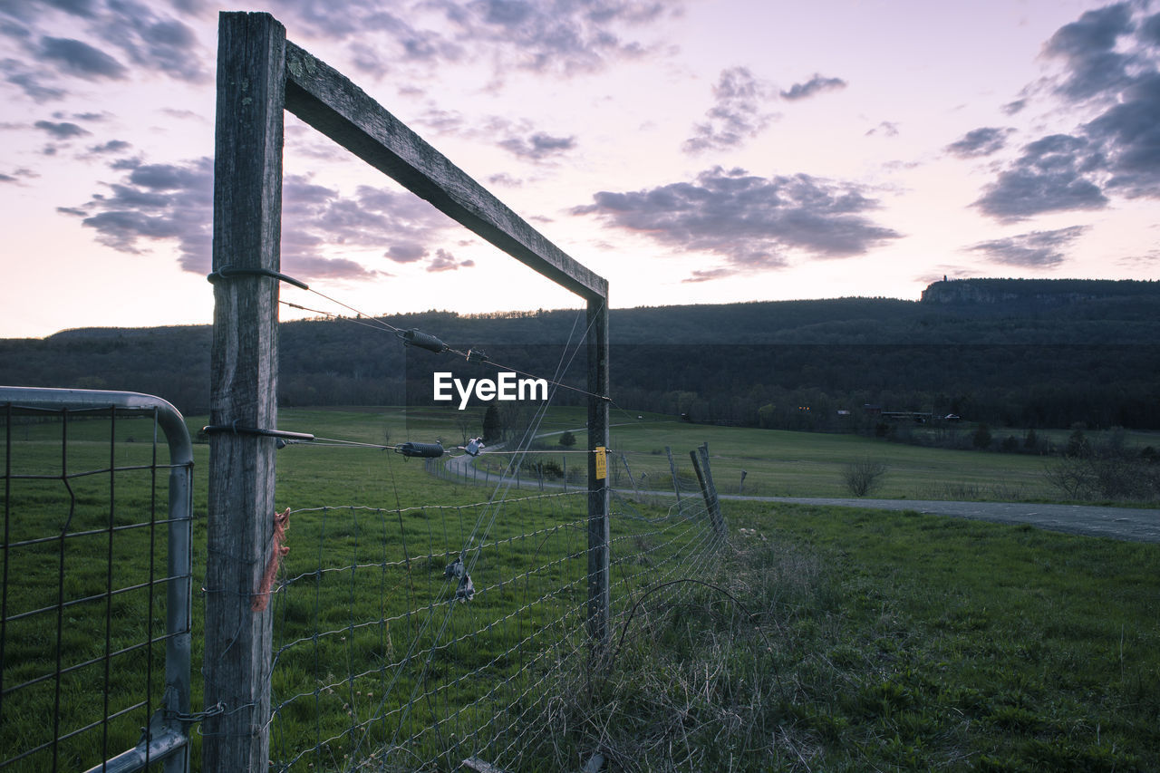 Built structure on field against sky during sunset