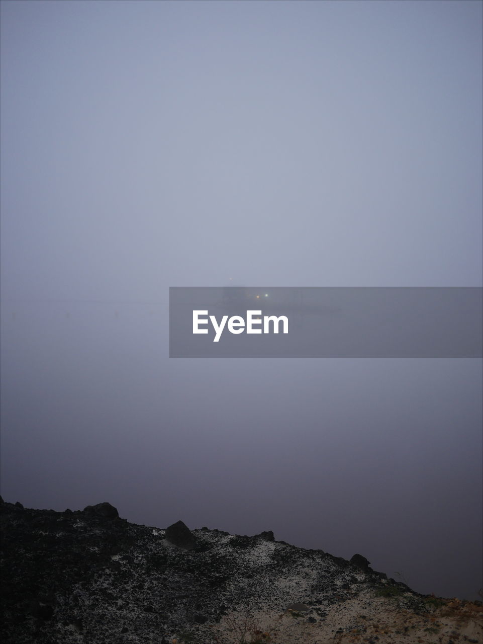 Scenic view of sea against clear sky during foggy weather