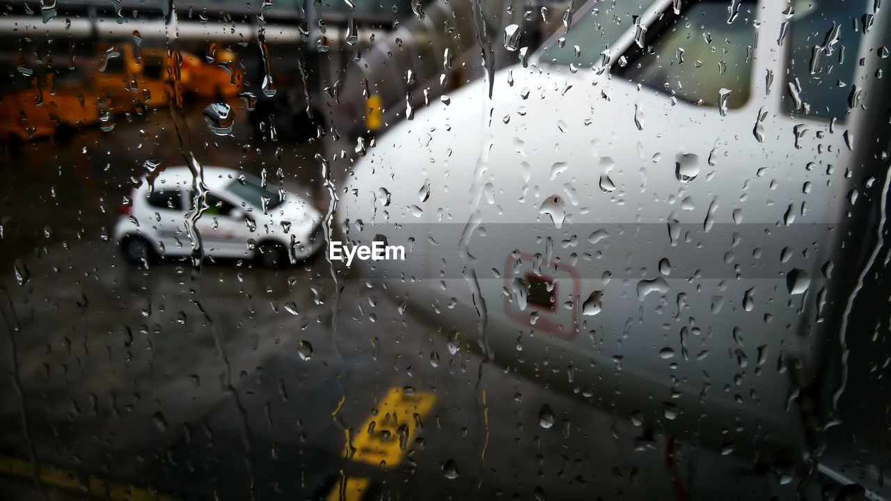 Airplane seen through wet car window