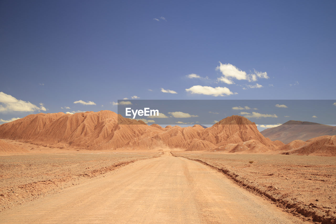 scenic view of road by mountains against sky