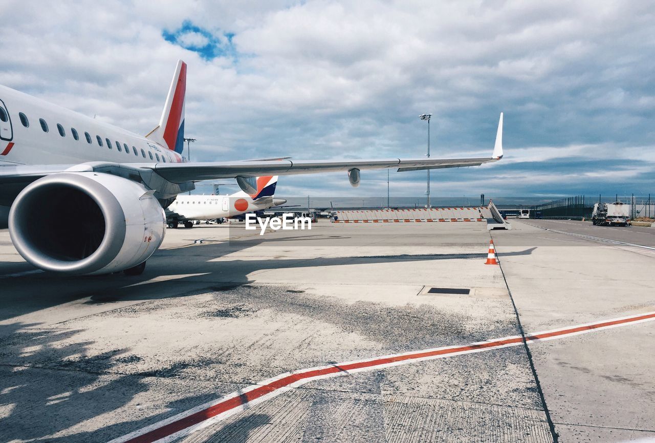 AIRPLANE ON AIRPORT RUNWAY AGAINST ROAD