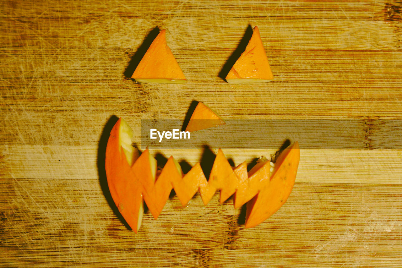 High angle view of carved pumpkin on wooden table