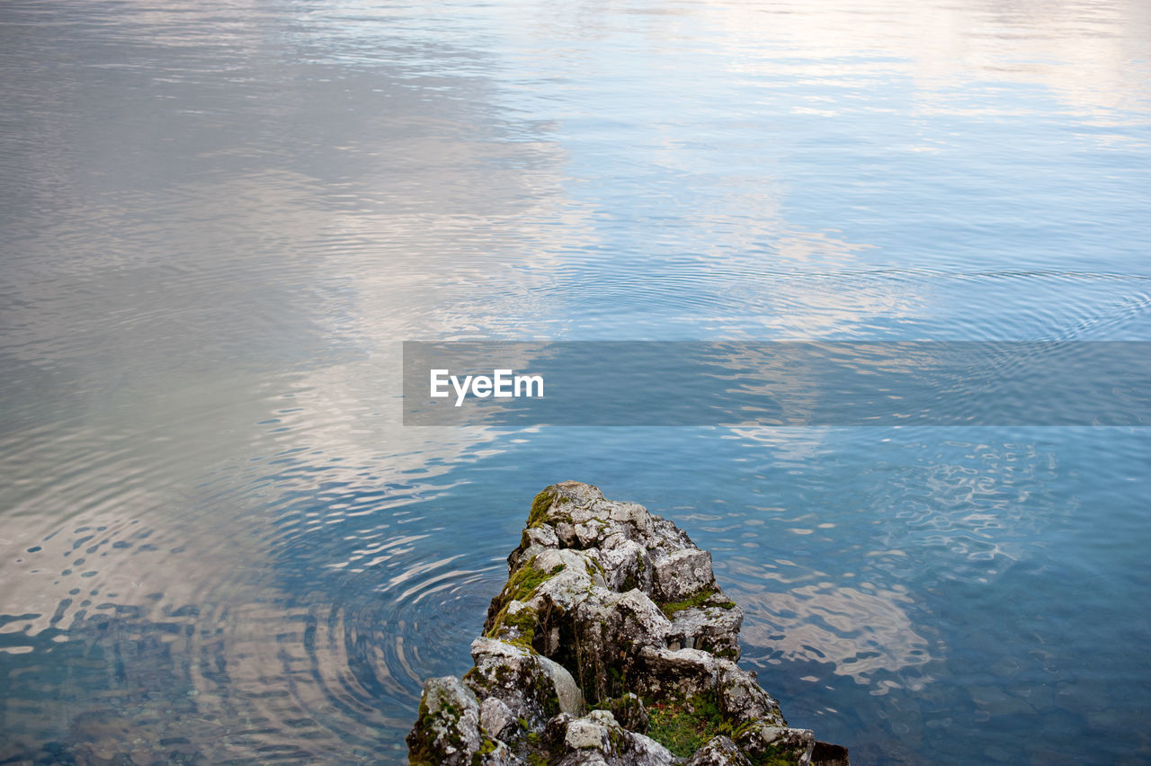 HIGH ANGLE VIEW OF ROCKS IN CALM LAKE