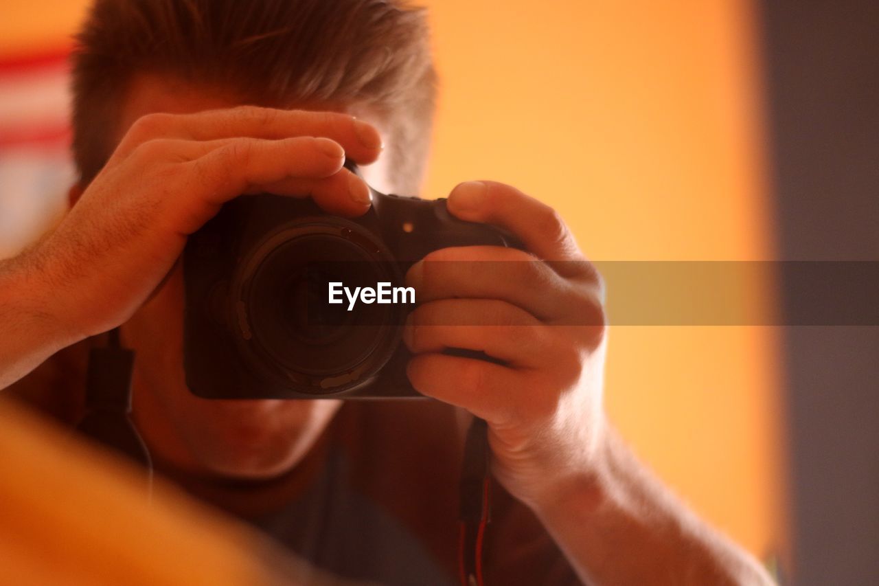 Close-up of man looking through camera