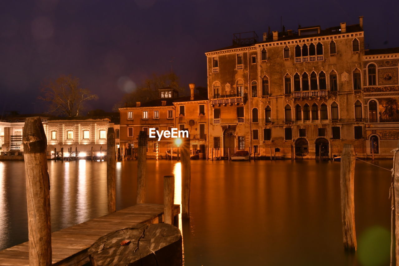 Reflection of buildings in lake at night