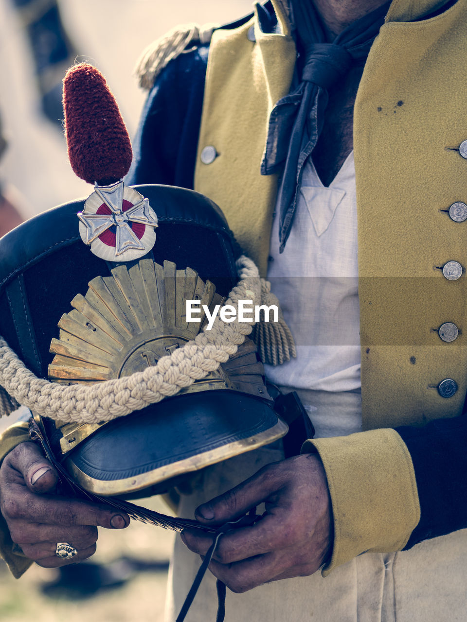 Midsection of soldier holding cap