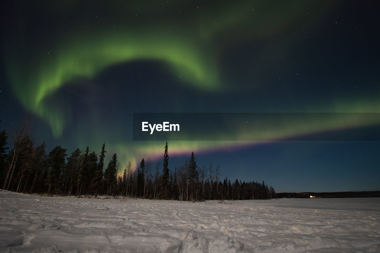 Breathtaking green dancing aurora borealis in the dark sky in sirkka, lapland, northern finland.