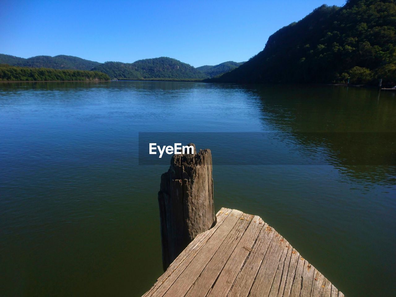 WOODEN JETTY ON LAKE AGAINST SKY