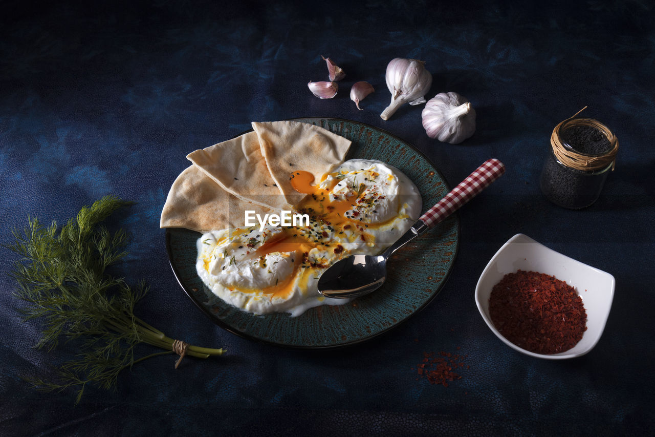 Turkish eggs cilbir, plain yogurt, poached eggs, garlic, chilli, fresh dill and melted butter. 