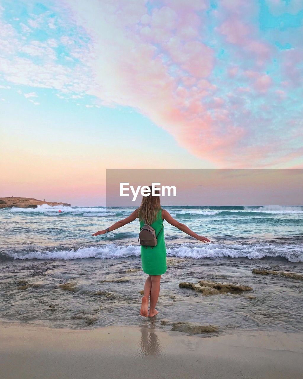 FULL LENGTH REAR VIEW OF MAN STANDING ON BEACH AGAINST SKY