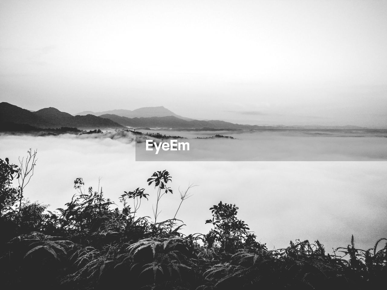 Idyllic shot of mountains in foggy weather against sky