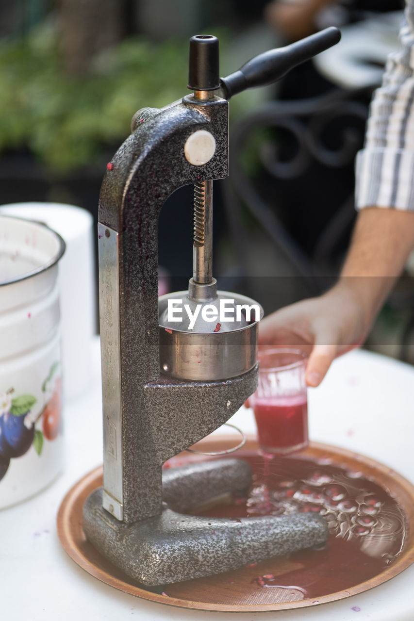 Process of squeezing pomegranate juice using manual mechanical juicer to obtain useful vitamins