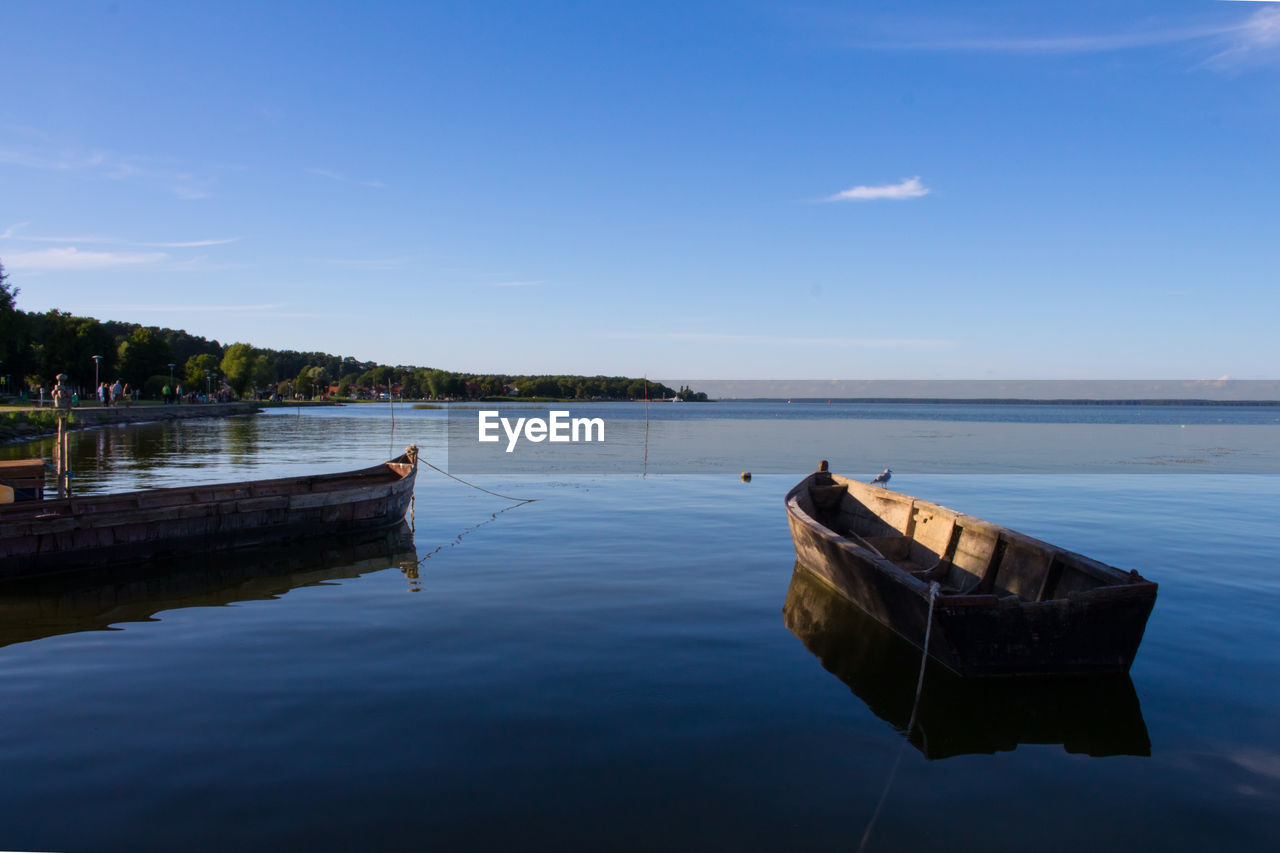 Boats moored on river against clear sky