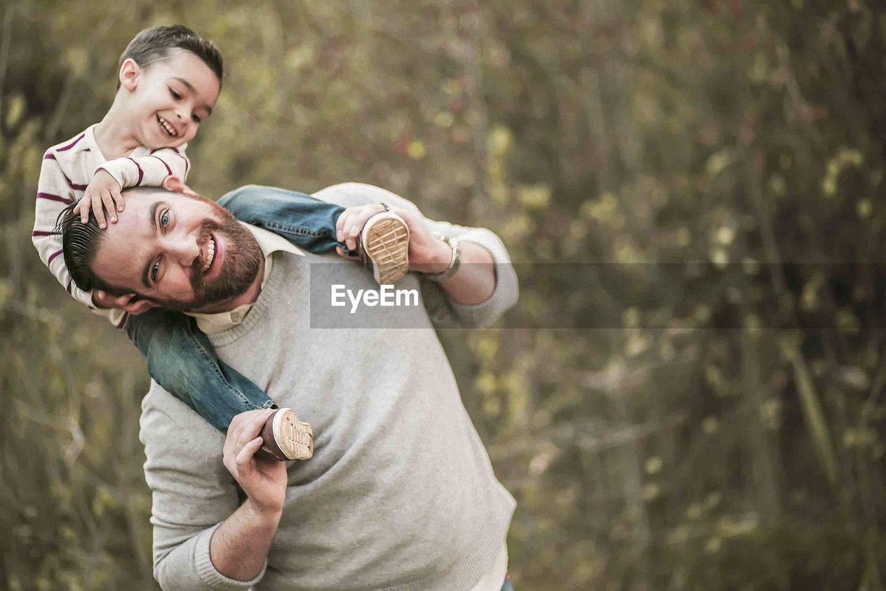 Portrait of a father carrying son on shoulders