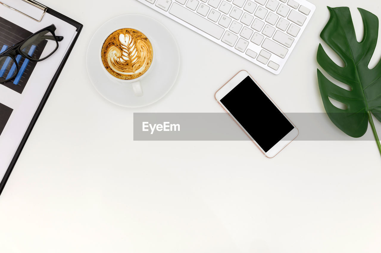 HIGH ANGLE VIEW OF COFFEE CUP AND LAPTOP ON TABLE