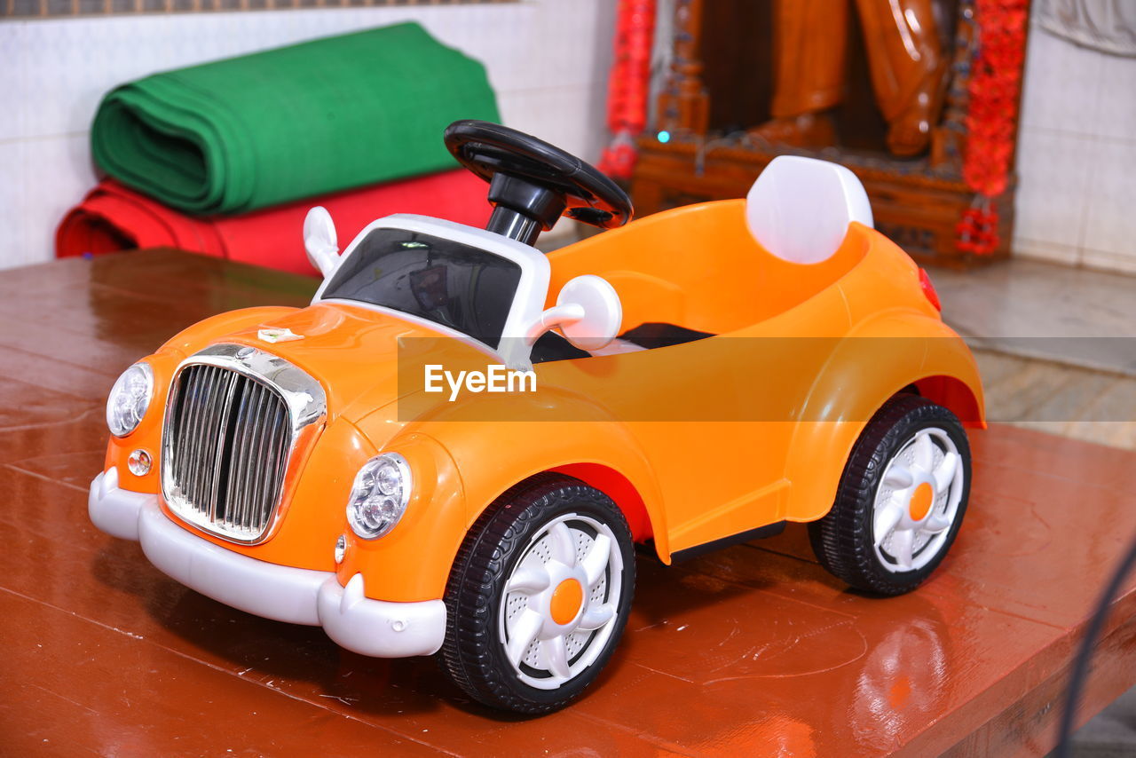 HIGH ANGLE VIEW OF TOY CAR ON SHELF