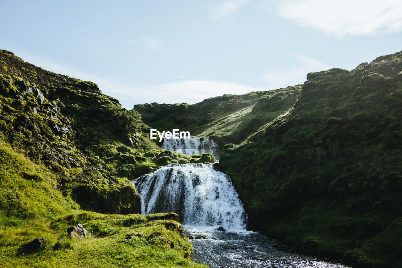 Scenic view of waterfall against sky