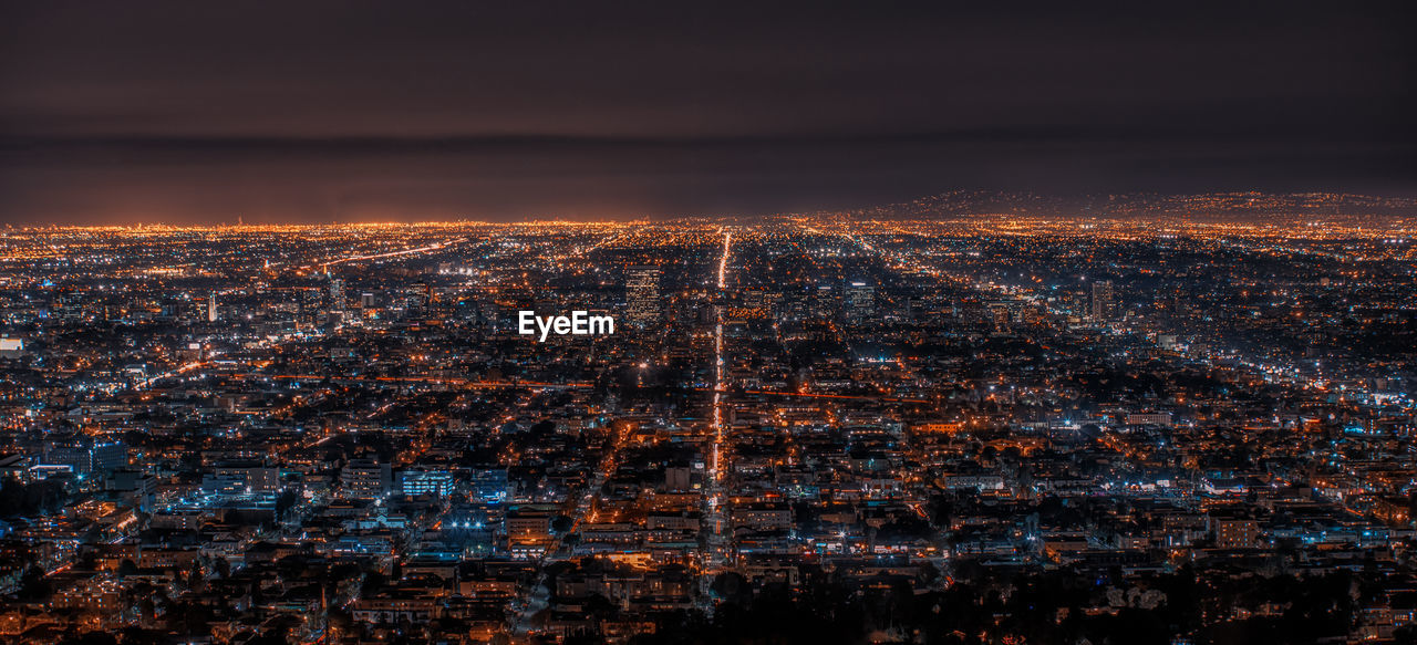 High angle view of illuminated city against sky at night