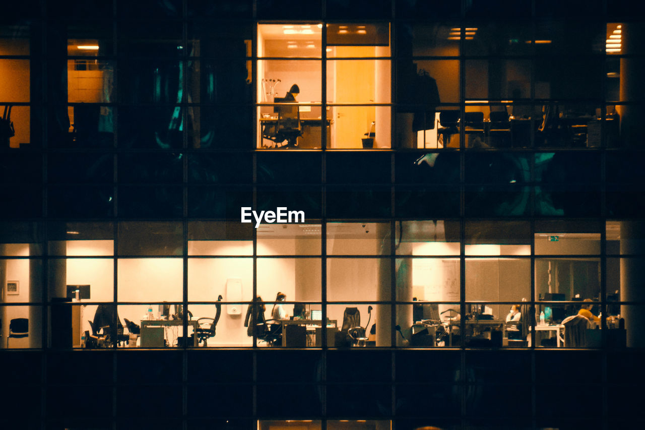 Group of people in glass building at night