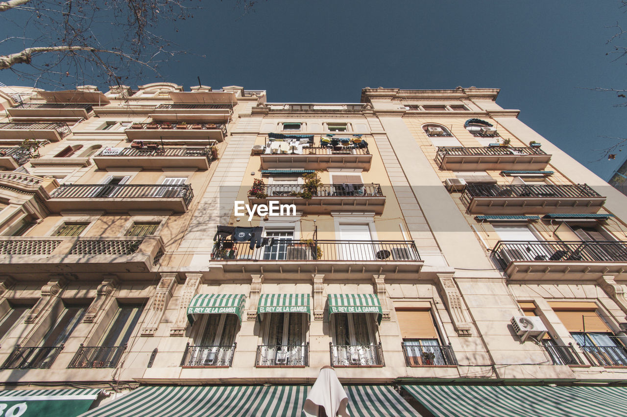 LOW ANGLE VIEW OF RESIDENTIAL BUILDING AGAINST CLEAR SKY